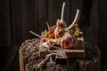 Hot roasted lamb ribs on old wooden stump