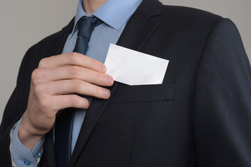 Businessman ,Business Man's hand hold showing business card - close up shot on grey background. Show a blank piece of paper. Paper visit card