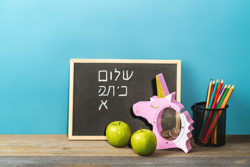 inscription in Hebrew Back to school on chalkboard background. Back to school concept. - obrazy, fototapety, plakaty