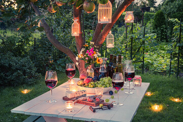 Stunning table full of wine, cheese and snacks at dusk