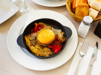 fried goat cheese with vegetables in iron skillet