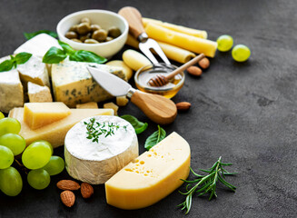 Various types of cheese, grapes, honey and snacks