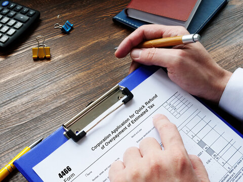 Business concept about Form 4466 Corporation Application for Quick Refund of Overpayment of Estimated Tax with sign on the page.