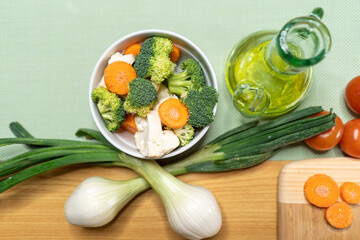 Overhead shot of a wooden board with different kinds of cut vegetables on it