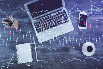 Double exposure of forex chart drawing over table background with computer. Concept of financial research and analysis. Top view.