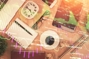 Double exposure of financial chart hologram over desktop with phone. Top view. Mobile trade platform concept.