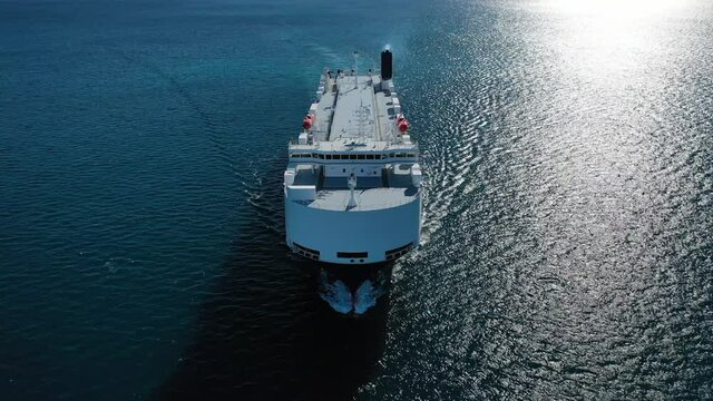 Aerial drone top down video of Large RoRo (Roll on-off) automobile - car transportation, carrier vessel cruising the Mediterranean deep blue sea