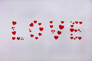 Lettering LOVE made of red hearts on white background. Valentine's Day, February 14, love concept.