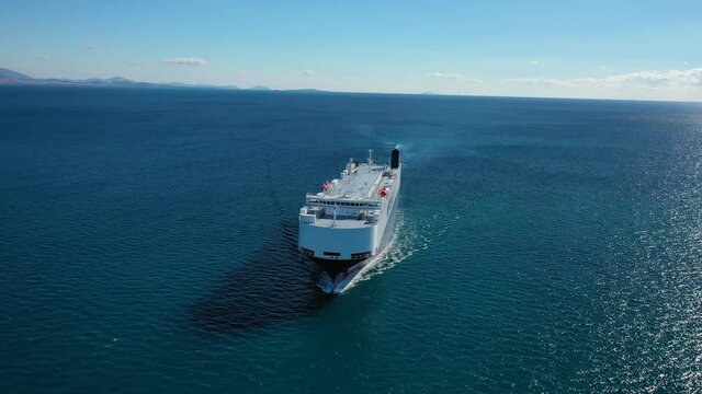 Aerial drone top down video of Large RoRo (Roll on-off) automobile - car transportation, carrier vessel cruising the Mediterranean deep blue sea
