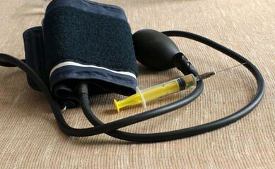 Medical tonometer and syringe on the table. Measuring the blood pressure.
