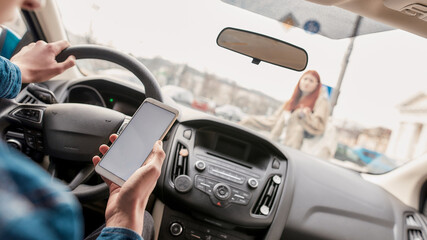 Distracted young male driver using his mobile phone while running over a pedestrian. Technology and...