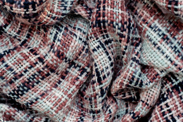 Checkered fabric for the background. Texture of a warm blanket close-up. Knitted fabric, cotton, wool background, loose pleats.