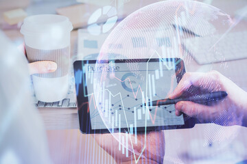 Double exposure of man's hands holding and using a phone and financial chart drawing. Market analysis concept.