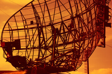Military locator close-up. Radar on the background of the sunset orange sky - 406073549