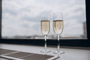 Two glasses of champagne stood on the windowsill