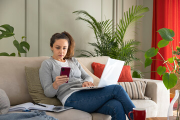 Young woman using laptop on sofa.