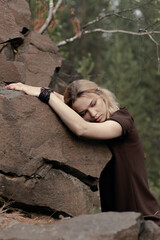 Beautiful girl in a dress on the rocks