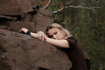 Beautiful girl in a dress on the rocks