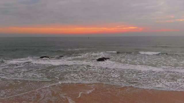Movment of drone forword on the wave, beach and rocks over the sunrise in the morning at Hua Hin,  Thailand.