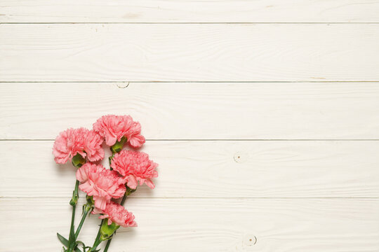 Pink carnation flower bouquet on rustic wood.