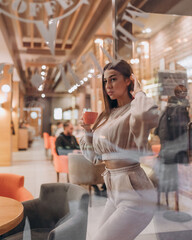 beautiful girl with dark long hair sitting in a cafe in the evening