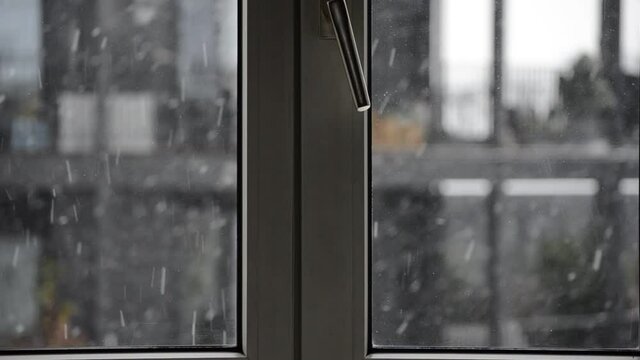 Chute de neige &agrave; travers une fen&ecirc;tre