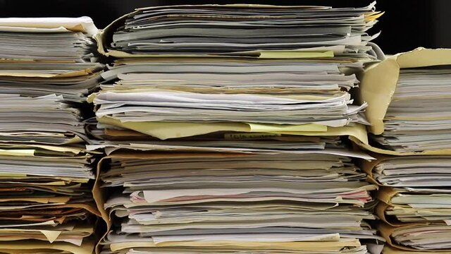 Close-up of files in folders stacking up in a messy order.