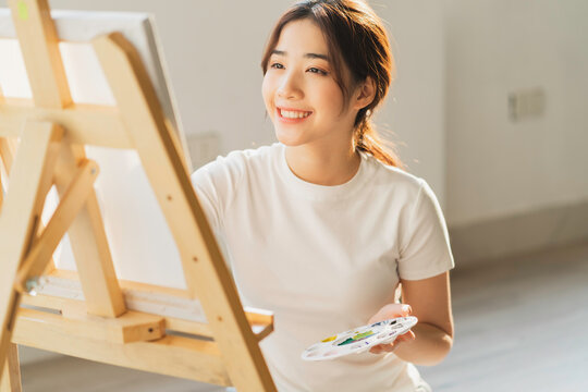 Young girl sitting on the floor learning to draw by herself