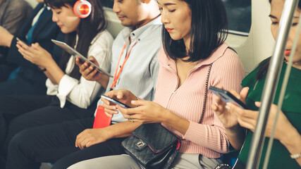 Young people using mobile phone in public underground train . Urban city lifestyle and commuting in...