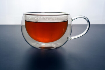 Glass cup with tea on a black and white background.