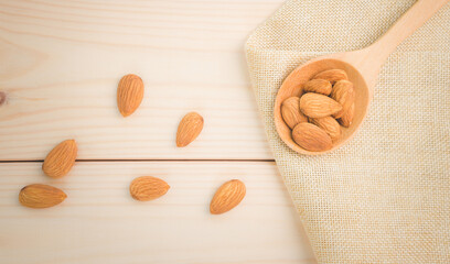 Almonds raw peeled in wooden spoon on wooden table background.Healthy food Concept.