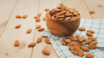 Almonds in brown wooden bowl on wooden table background.Healthy food Concept.