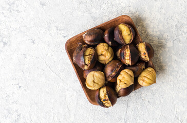 Roasted chestnut on wooden plate.