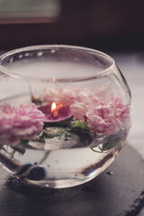 tea rose. the atmosphere of relaxation and comfort. candles and roses in a container with water.