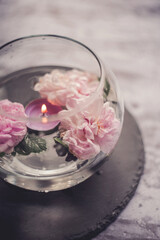 tea rose. the atmosphere of relaxation and comfort. candles and roses in a container with water.