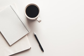 Office desk table with supplies, coffee cup and flower. Top view
