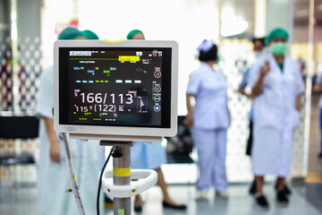 Modern vital sign monitor on patient background at ward in the hospital.