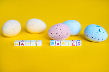 Easter greeting card with painted eggs. Seasonal Easter message Happy easter. Pastel and colorful decorated easter eggs with greeting card with text on yellow background. Spring holidays concept. 