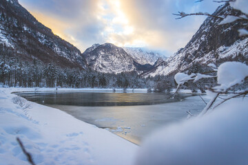 Winter landscape with frosty lake, snowy trees and mountains. Buntautal and Bluntausee.