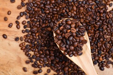 View from above of coffee beans in the wooden spoon on top of the pile of coffee beans 