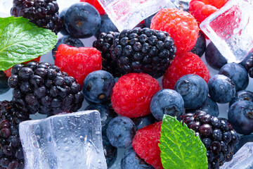 Selective focus shot of melting ice cubes and various delicious berries © Natalie Portman/Wirestock