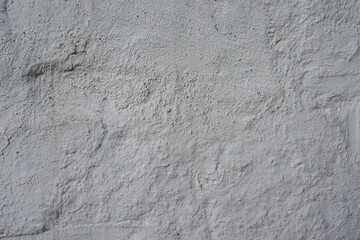 Concrete wall, sand plaster. Scratched and cracked concrete weathered with moss, stone wall