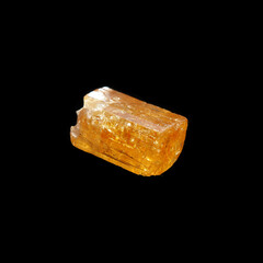 crude golden topaz on black background 
