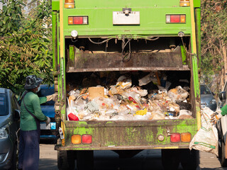 garbage collection service the full garbage truck press waste from garbage collector team who pickup trash to dispose junk for cleanup urban city and environment conservation © MrBoonmee