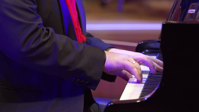 Man touches fingers on keys . Pianist plays in beautiful grand piano on stage in concert . Close up grand piano. Professional pianist
