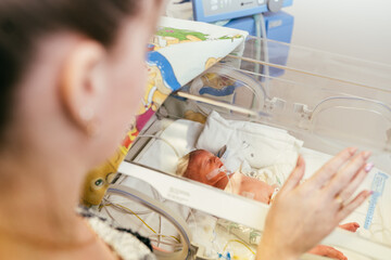 Portrait of Premature newborn baby sleeping in incubator , ICu. - obrazy, fototapety, plakaty