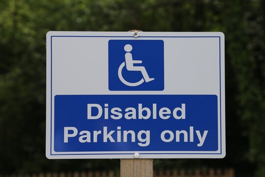  A closeup view of a disabled parking sign in a carpark.