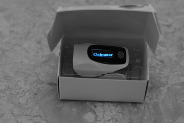 a closeup for a fingertip pulse oximeter that measures the oxygen saturation of the blood and the pulse rate for Covid 19 pandemic , Corona virus measurement of oxygen saturation level 