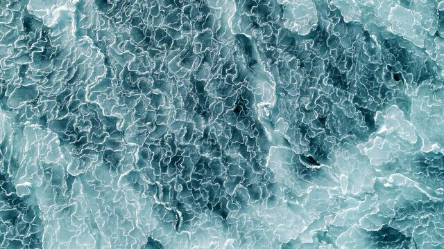Aerial shot of abstract ice surface frozen blue sea. Drone top down. 4k