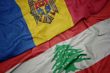 waving colorful flag of lebanon and national flag of moldova.